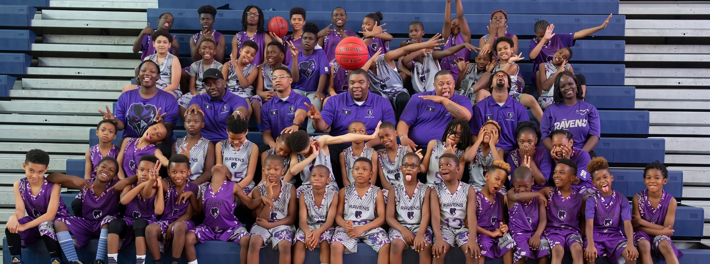 Group of kids and adults wearing Ravens themed shirts and uniforms.